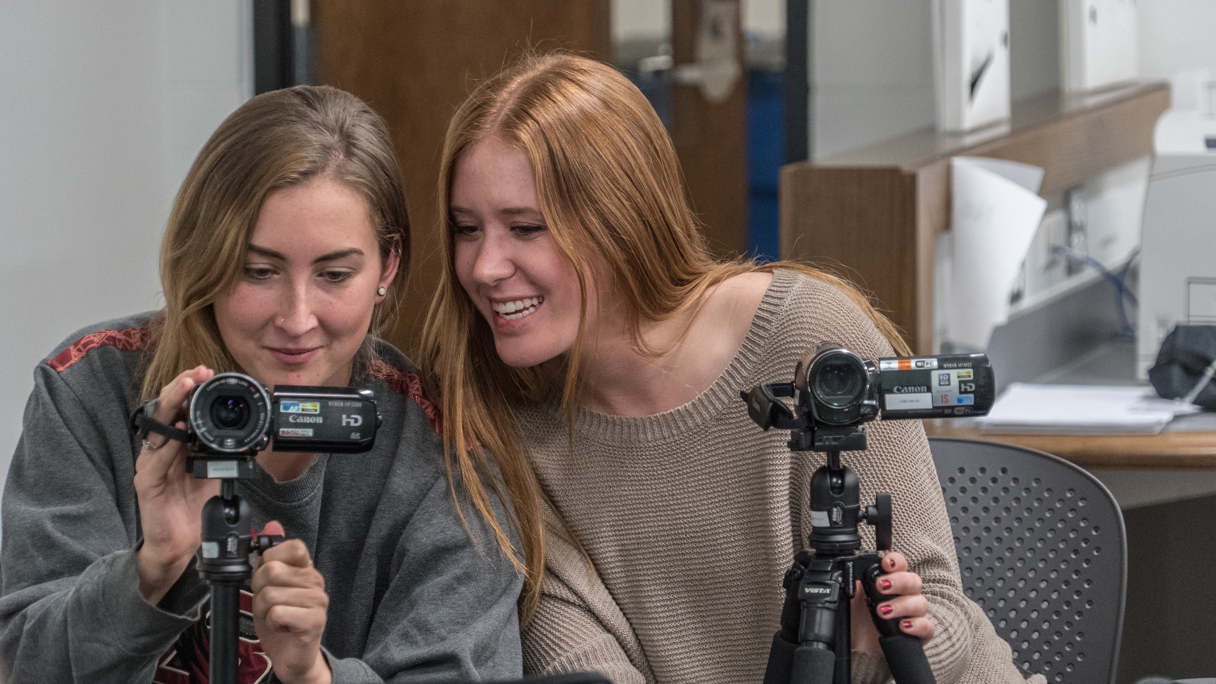 Two students work with camera equipment.