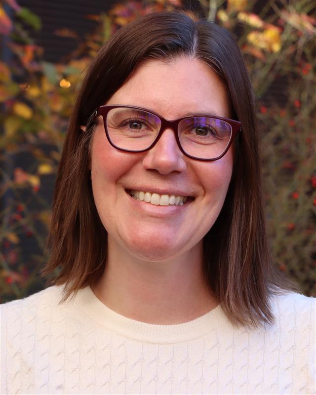 A woman smiles at the camera.