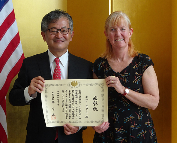 Bonnie Clark receives a commendation from the Denver's Consul General to Japan Mikami Yoichi.