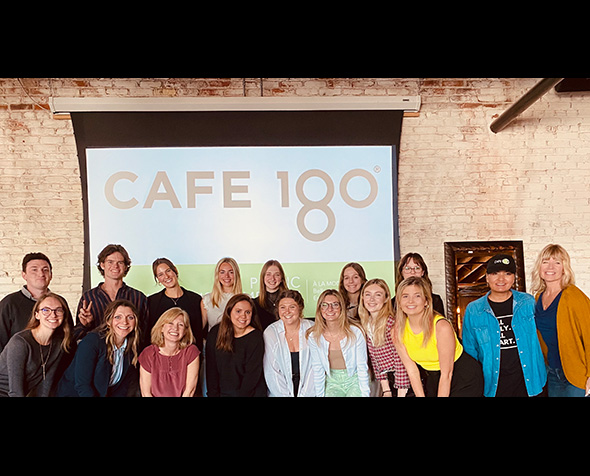 Students in the Spring 2022 Strategic Communication Seminar pose with staff from Cafe 180 in front of their strategic communication plan presentation