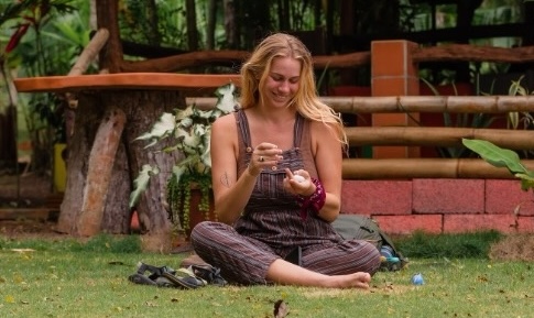 A woman sits on the grass.