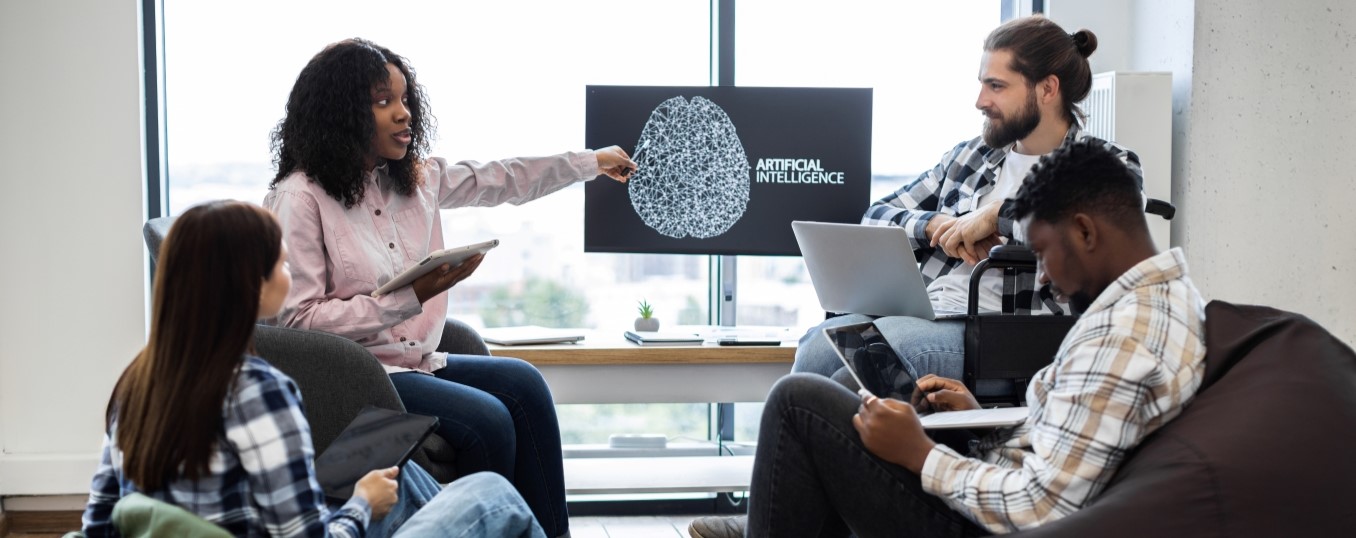 People are sitting around pointing and looking at a computer screen.