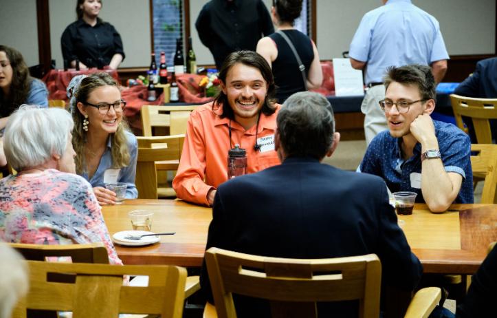 Alumni seated at table in conversation