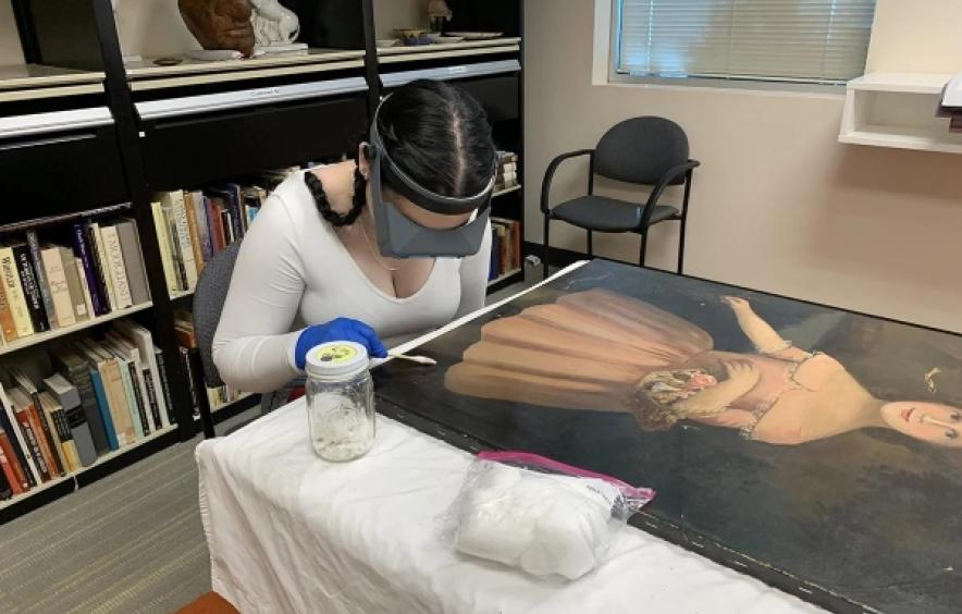 A student wears special glasses and looks at a painting.