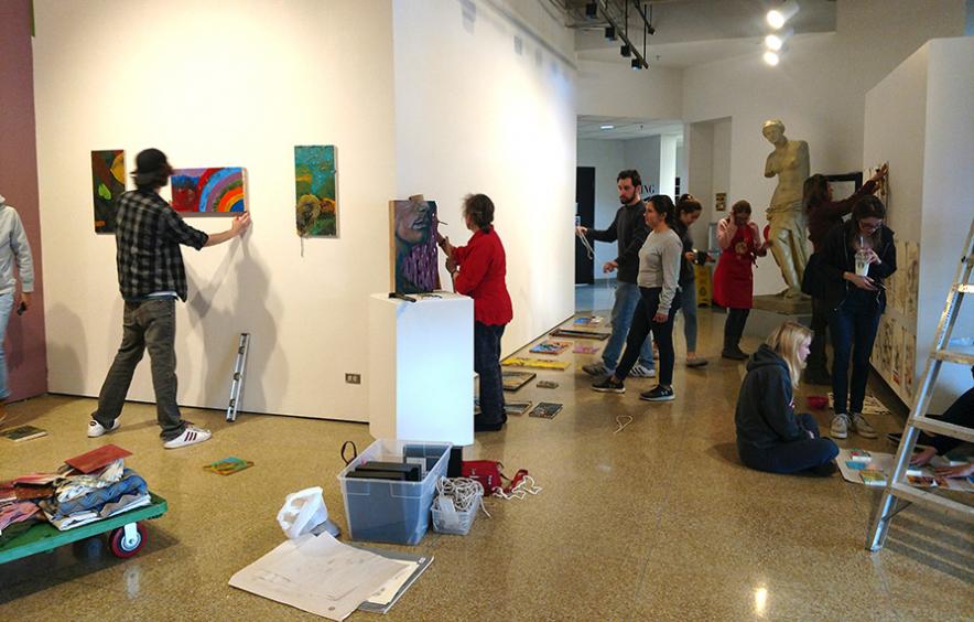 students hanging work in gallery