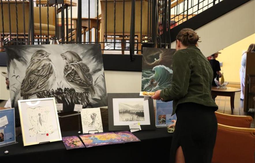 A woman looks at paintings created by an incarcerated artist.