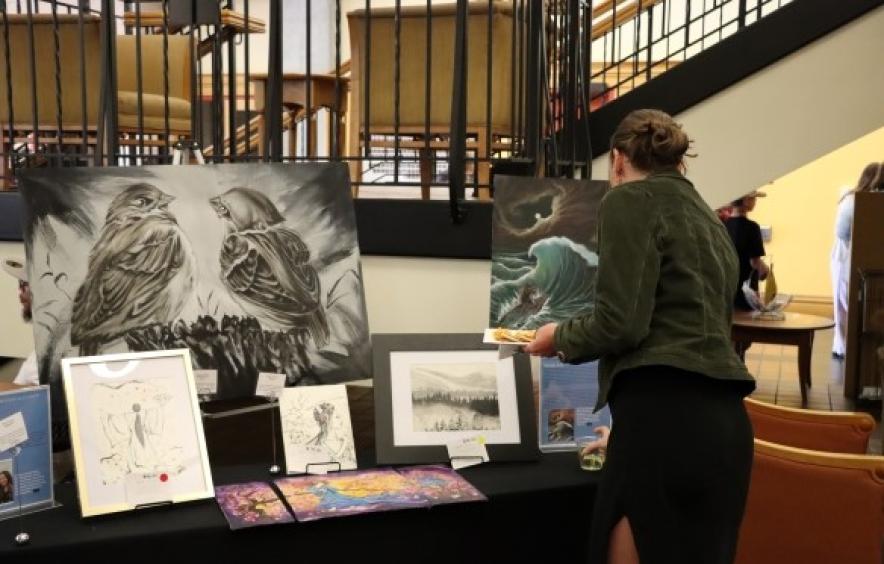 A woman looks at paintings created by an incarcerated artist.