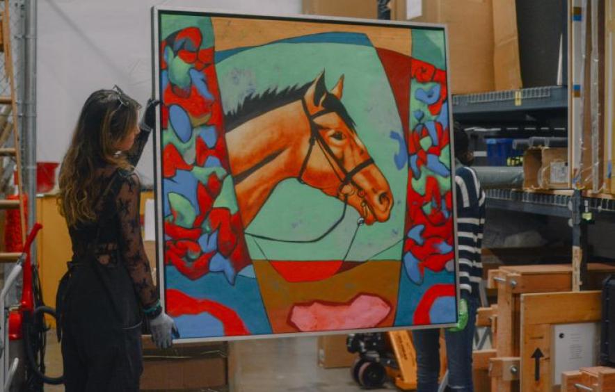 art history graduate students carry a painting at the University Art Collections