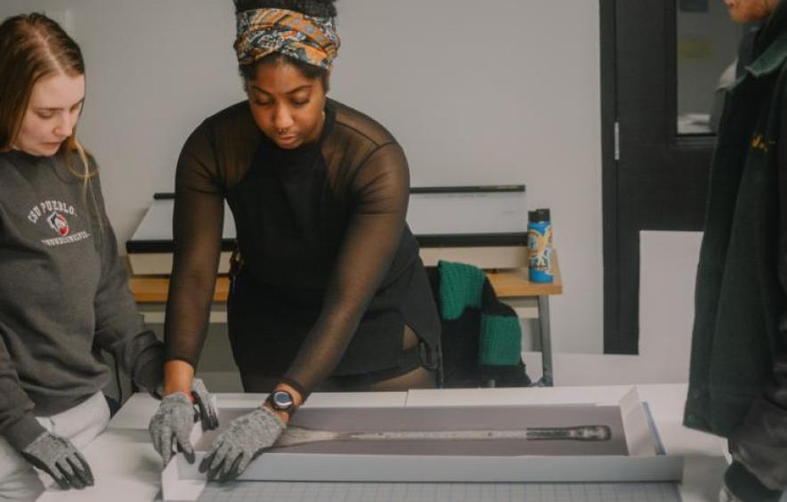 Graduate students during a workshop learn how to "collar" paintings