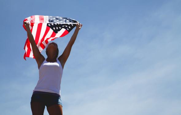 Photo of woman holding an American flag by Josh Willink