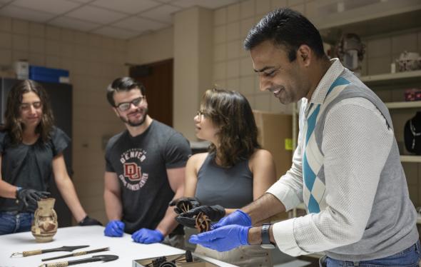 Students engaging with Museums objects around a table