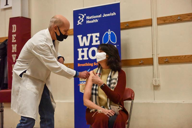 Doctor giving covid vaccine to patient