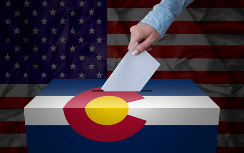 hand-puts-ballot-in-colorado-ballot-box