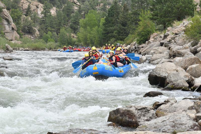 Whitewater rafters traverse down the water.