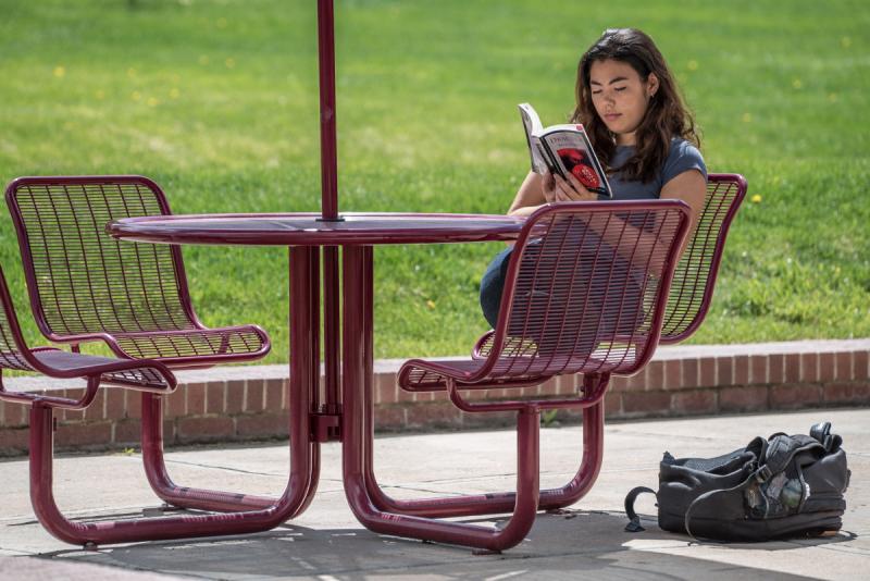 Student on campus reading a book