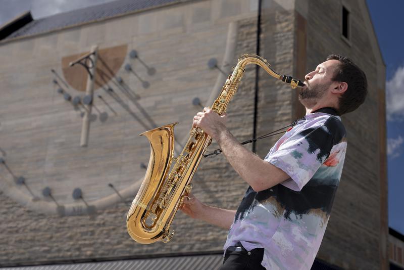Adam Gang plays the saxophone.