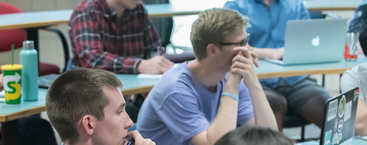 students watch economics lecture