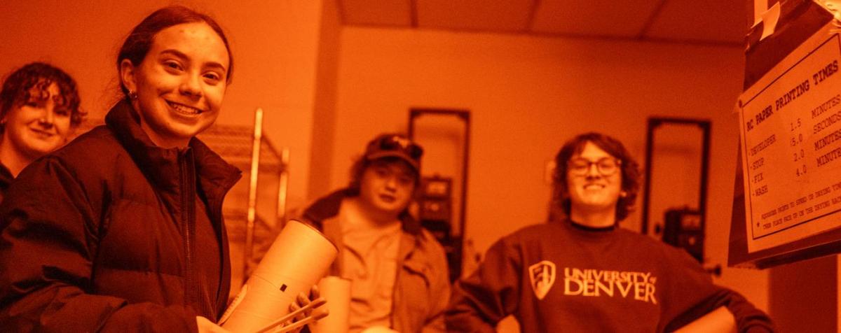 Students develop film in a dark room.