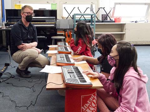Students playing keyboards in a classroom