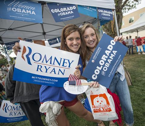 two girls holding political campaign signs