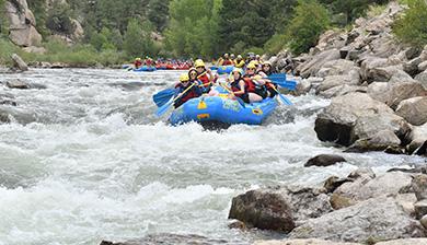 Whitewater rafters traverse down the water.
