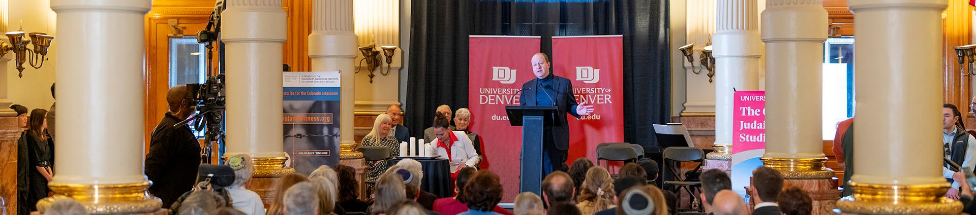 Governor Jared Polis speaking in the Colorado Capitol