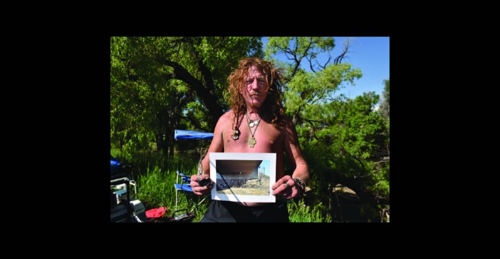 Man holding picture of former camp