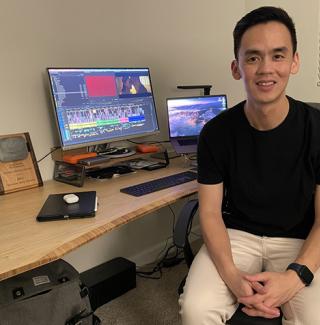 Lam Nguyen sits at his desk in front of his SXSW award plaque