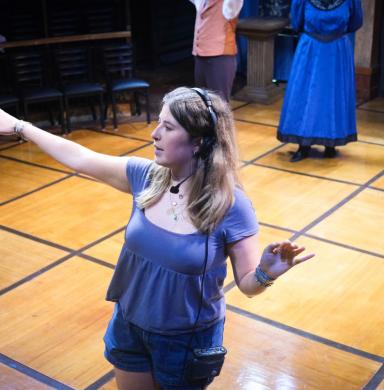 A woman directs a theater production.