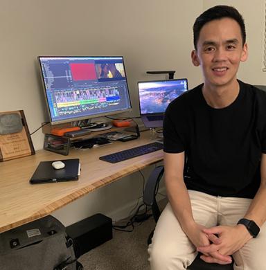 Lam Nguyen sits in front of his desk and his SWSW award plaque