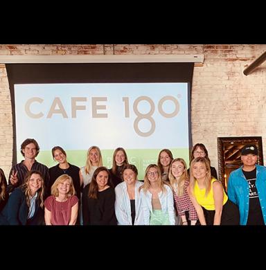 Students in the Spring 2022 Strategic Communication Seminar pose with staff from Cafe 180 in front of their strategic communication plan presentation