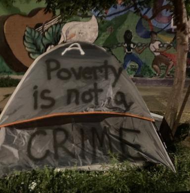 Photo of a tent with the text "Poverty is not a crime" 