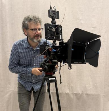 A man acts like he is using a camera.