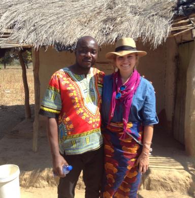 Elton Chimwemwe Chavura (left) and Ivey Bostrom (MA '18) stand in front of a building with a thatched roof in Malawi