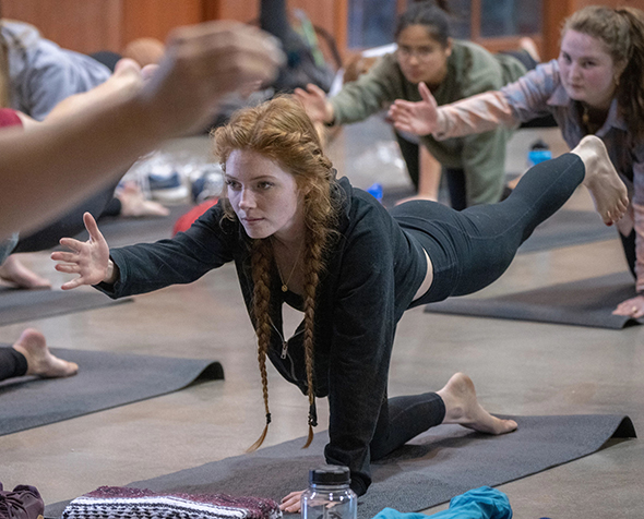 A student performs a yoga position at the Kennedy Mountain Campus.
