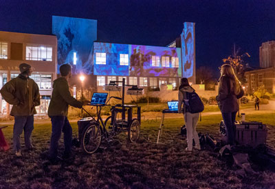 student projecting onto buildings