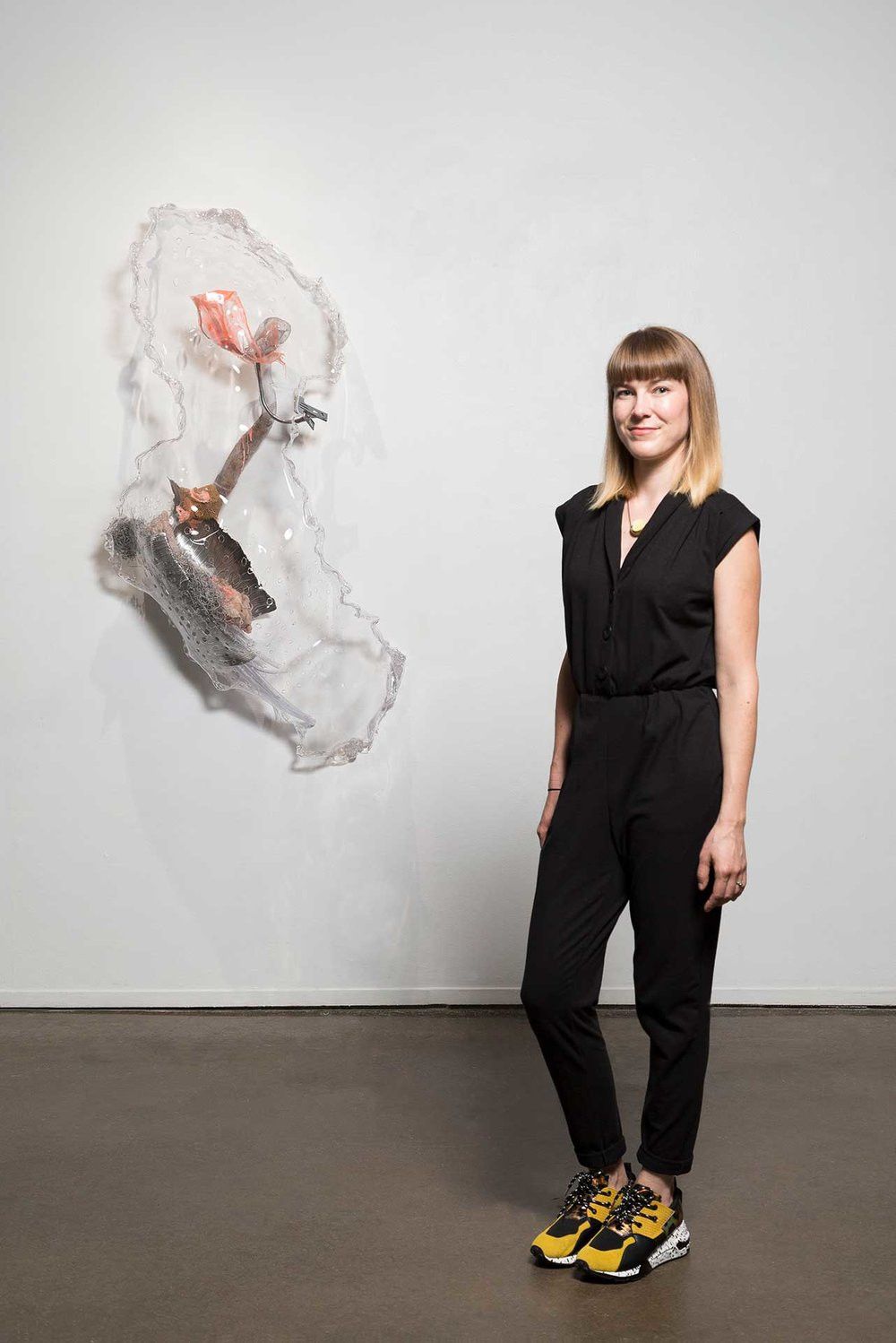 Kate Casanova standing in gallery next to artwork
